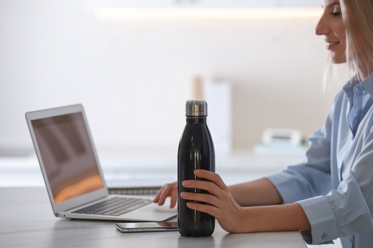 Woman,With,Thermo,Bottle,Working,At,Table,In,Modern,Office,