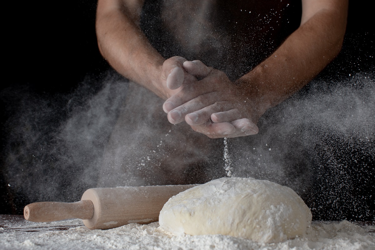 Closeup,Male,Hands,Knead,The,Dough,On,A,Dark,Background.