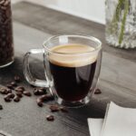 Double,Wall,Glass,Cup,With,Coffee,On,Wooden,Table