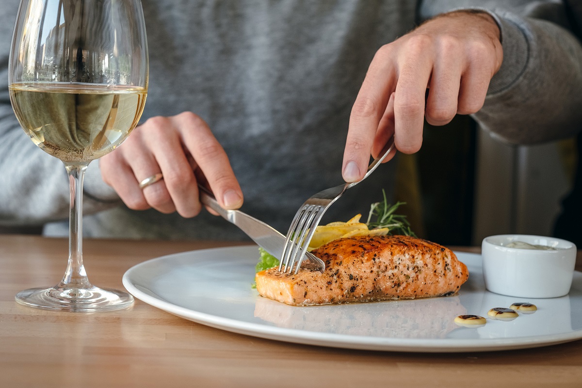 Horizontal,Close-up,Of,Man,Eating,Salmon,Fish,Steak.,Crispy,Grilled