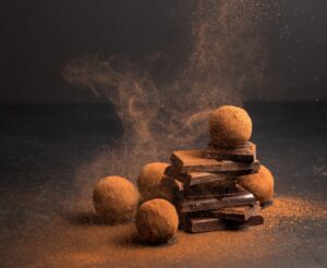 Chocolate,Candy,Truffle,With,Chocolate,Pieces,And,Flying,Cocoa,Powder