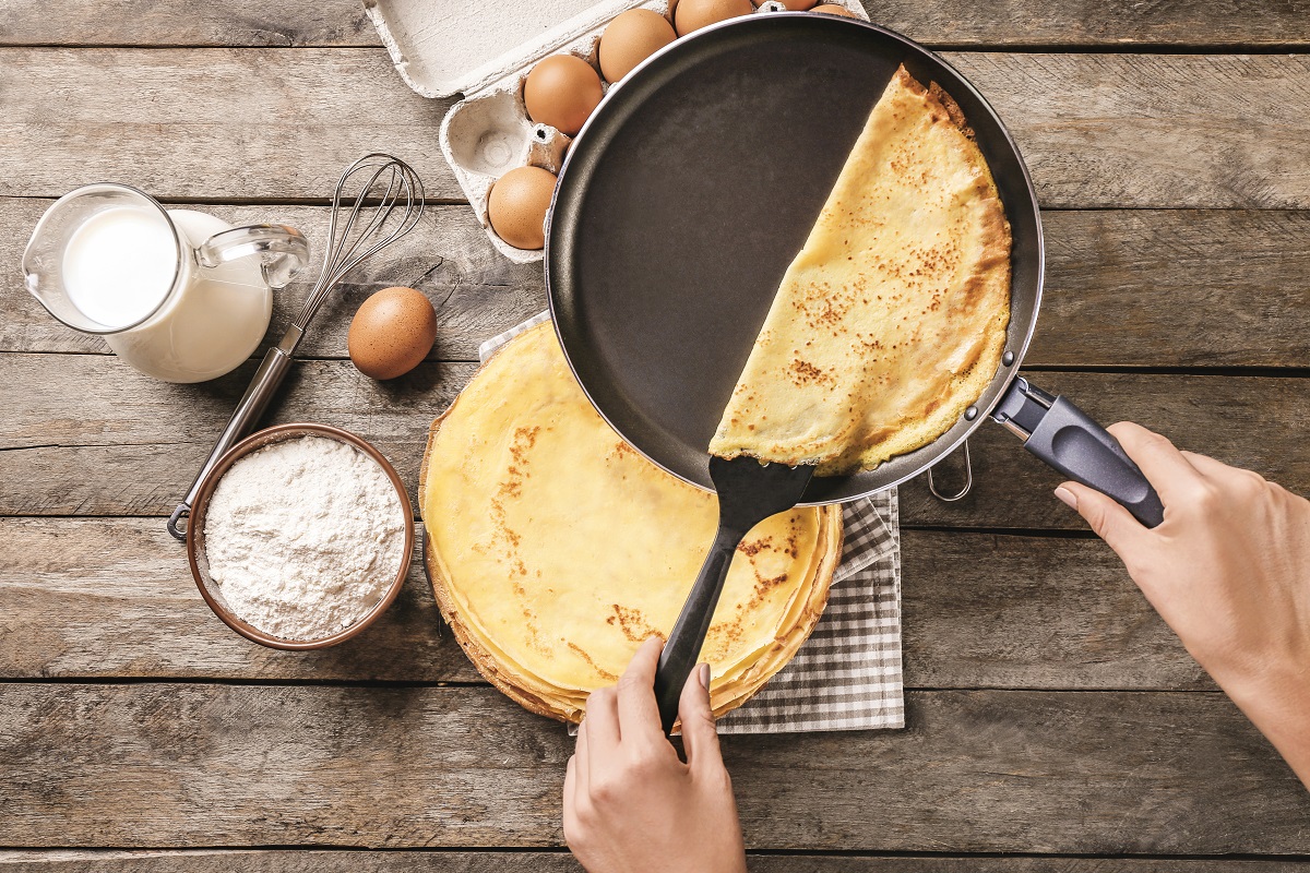 Woman,Making,Thin,Pancakes,On,Frying,Pan,In,Kitchen