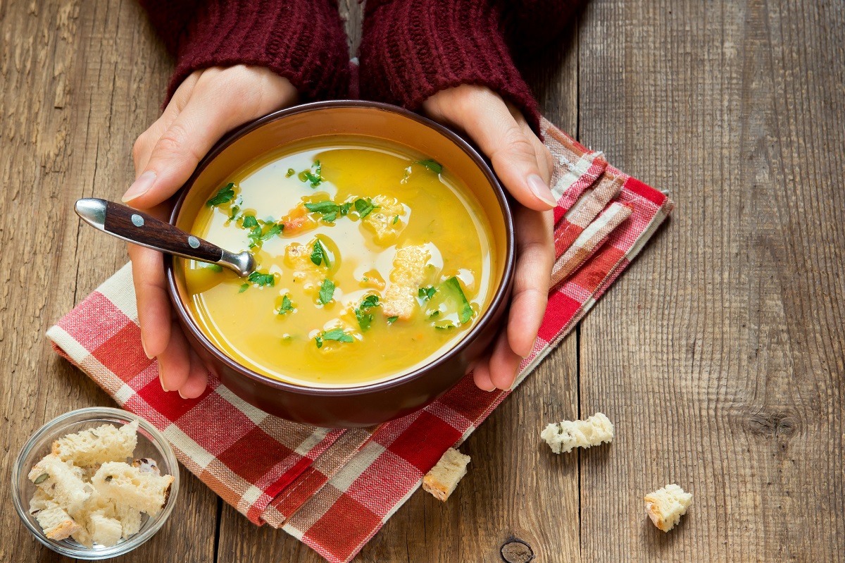 Woman,Hands,Holding,Bowl,Of,Vegetable,Soup,With,Parsley,And