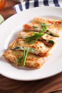 Healthy,Breakfast,Crepes,With,Bacon,,Cheese,,Greens,,Tomatoes,On,A