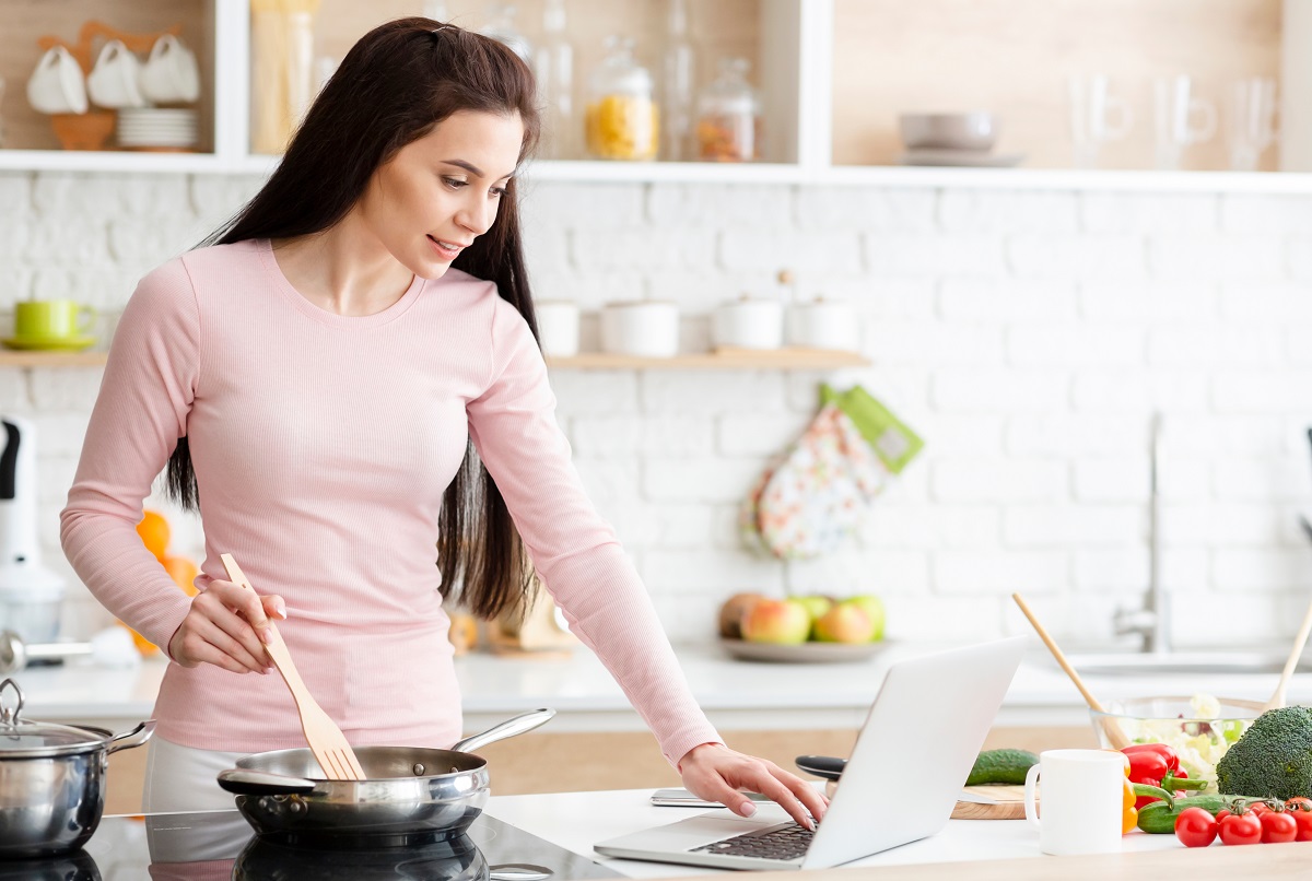 Millennial,Woman,In,Kitchen,Cooking,With,Reference,The,Laptop,,Empty
