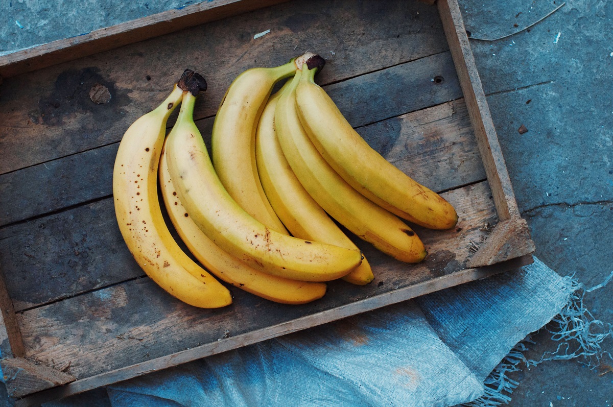Ripe,Yellow,Bananas,In,Wicker,Basket,,On,Wooden,Background,,View
