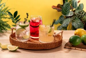 Sparkling,Cocktails,With,Ice,And,Citrus,On,A,Wicker,Tray.