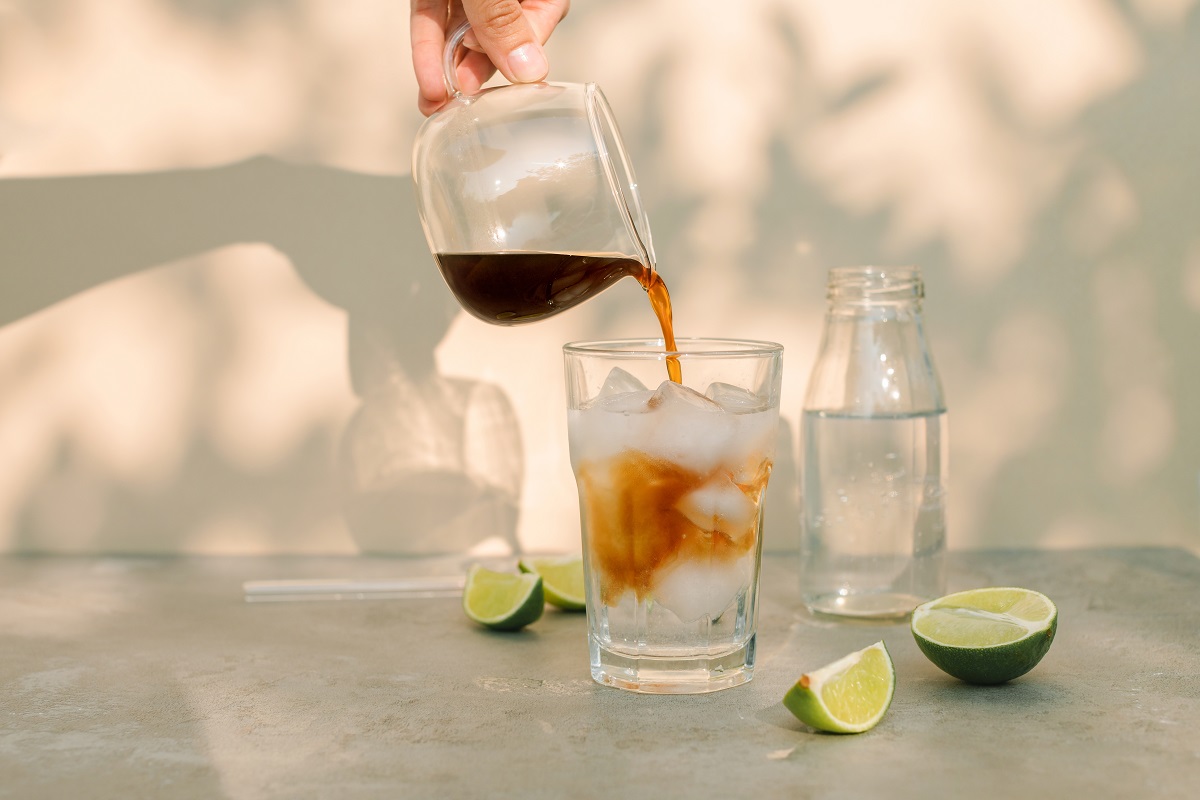 Woman,Pouring,Espresso,Into,A,Glass,With,Ice,Cubes,And