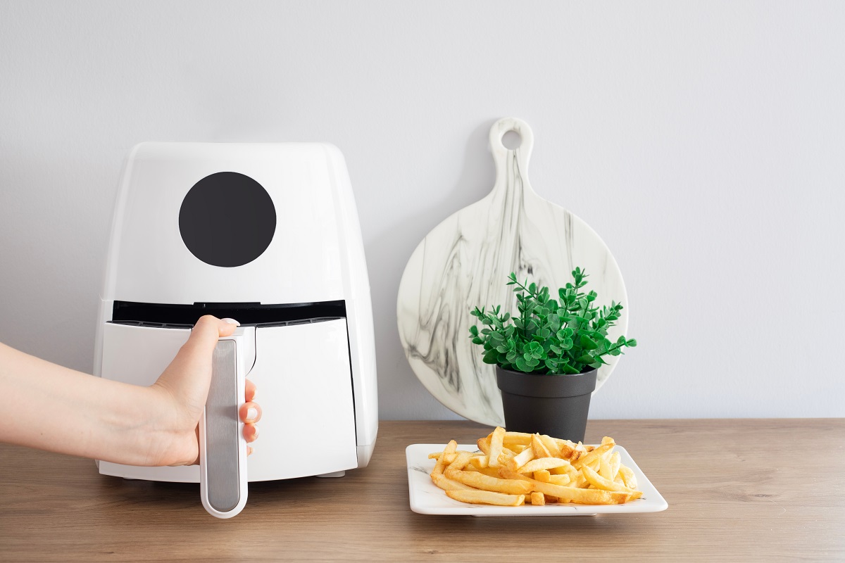 Woman,Cooking,With,Modern,Air,Fryer