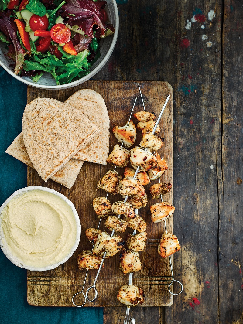 Greek chicken skewers with salad, hummus and pittas