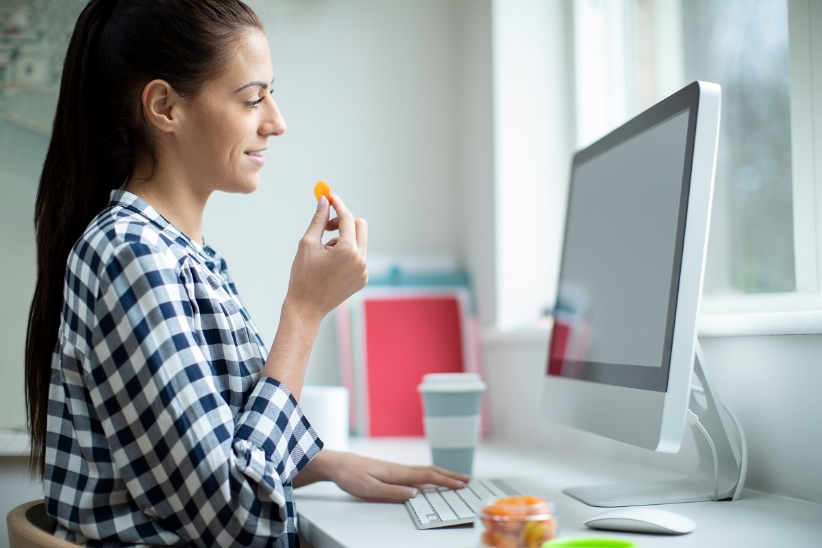 Female,Worker,In,Office,Having,Healthy,Snack,Of,Dried,Apricot