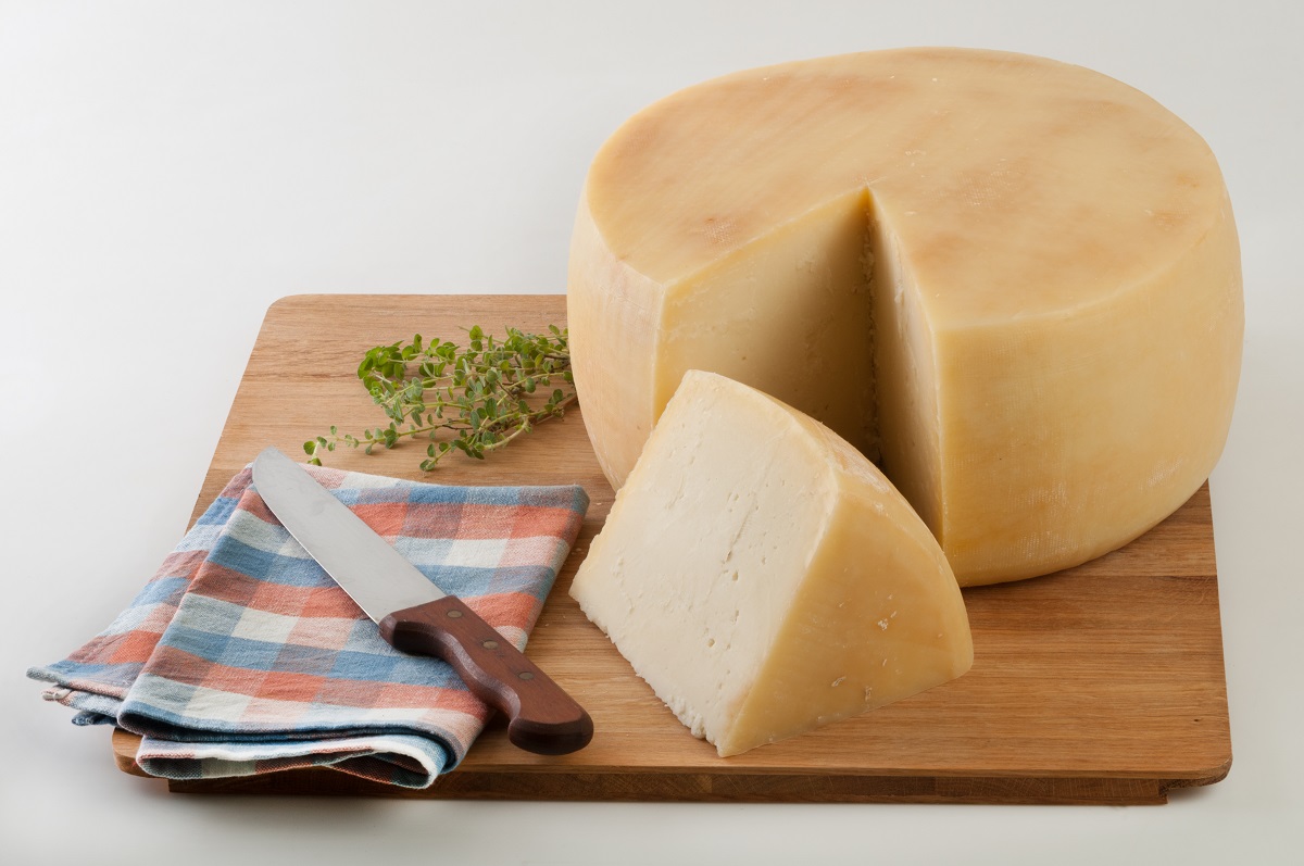 Wheel,Cheece,On,Wooden,Plato,Decorated,With,Oregano,And,Table