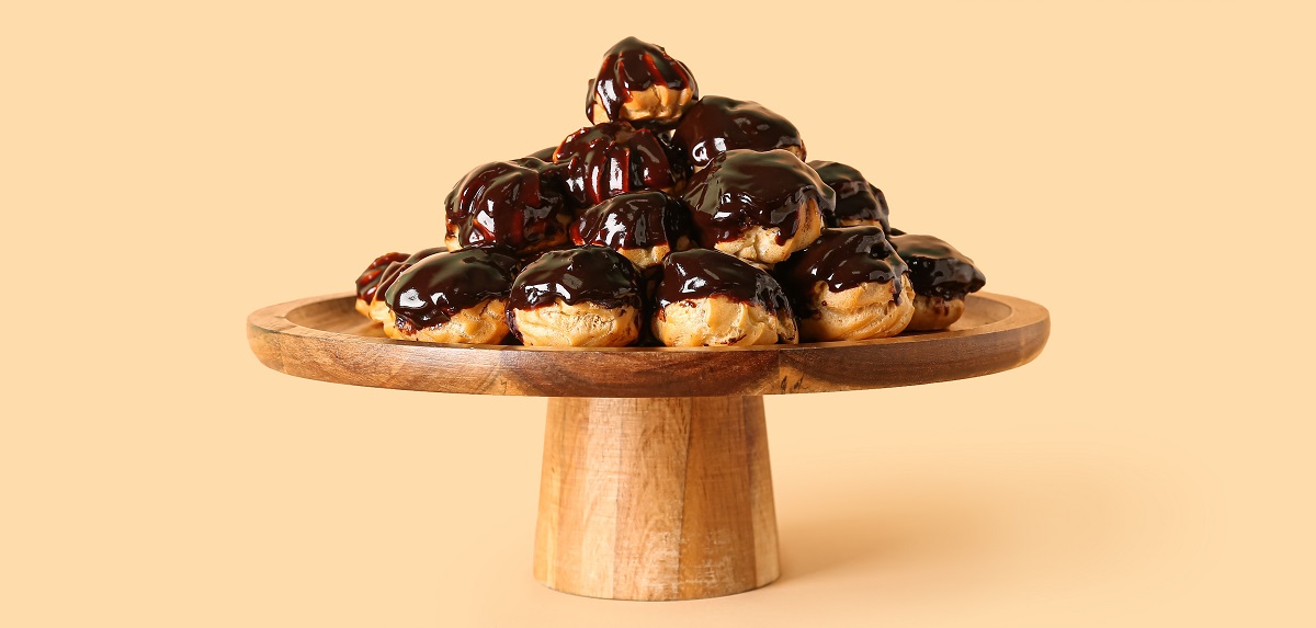 Wooden,Dessert,Stand,With,Delicious,Profiteroles,On,Beige,Background
