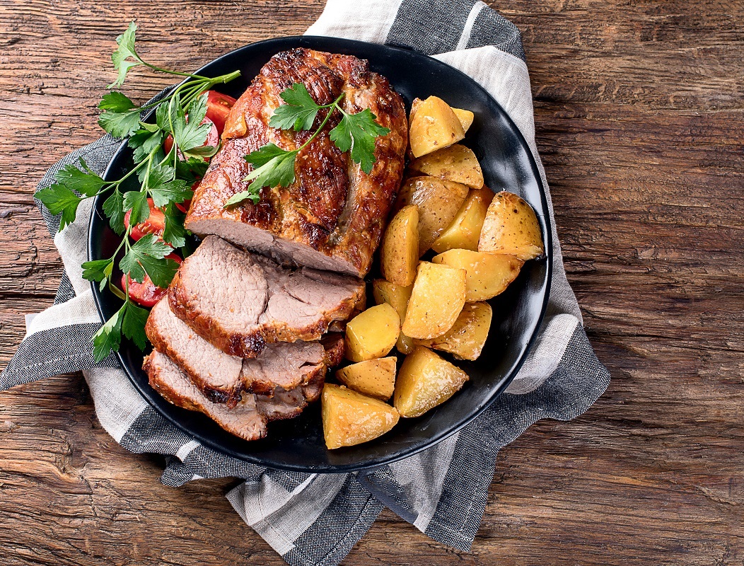 Roast,Pork,With,Herbs,And,Vegetables,On,Rustic,Wooden,Table.