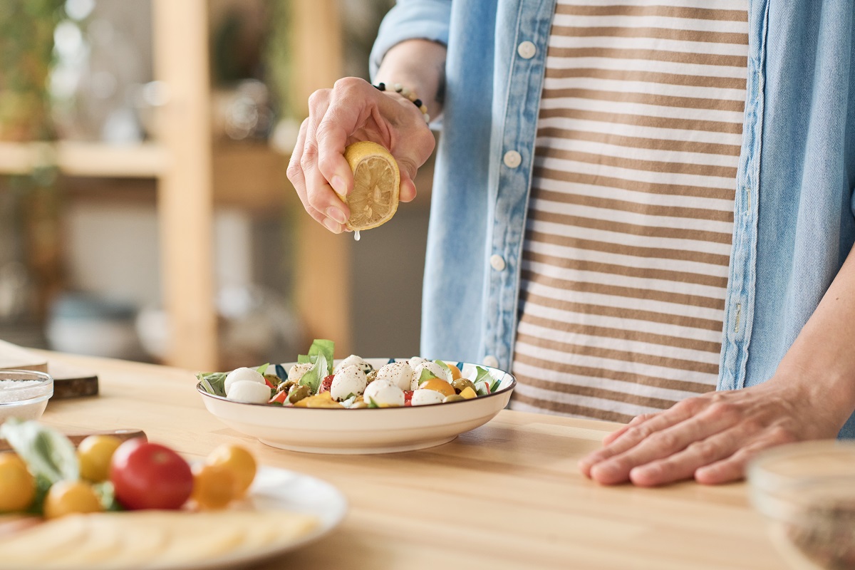 Close-up,Of,Young,Woman,Adding,Lemon,Juice,In,Vegetable,Salad