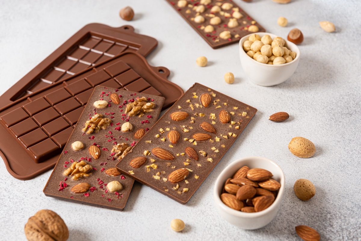 Milk,Chocolate,Bars,With,Nuts,On,Light,Background,With,Molds.