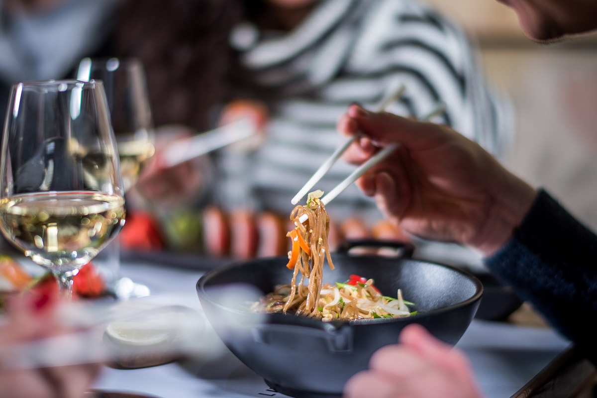 Hands eat noodle with chopsticks