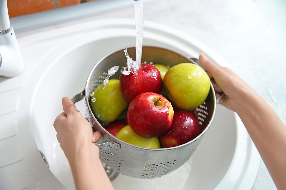 Young,Woman,Washing,Ripe,Apples,In,Kitchen