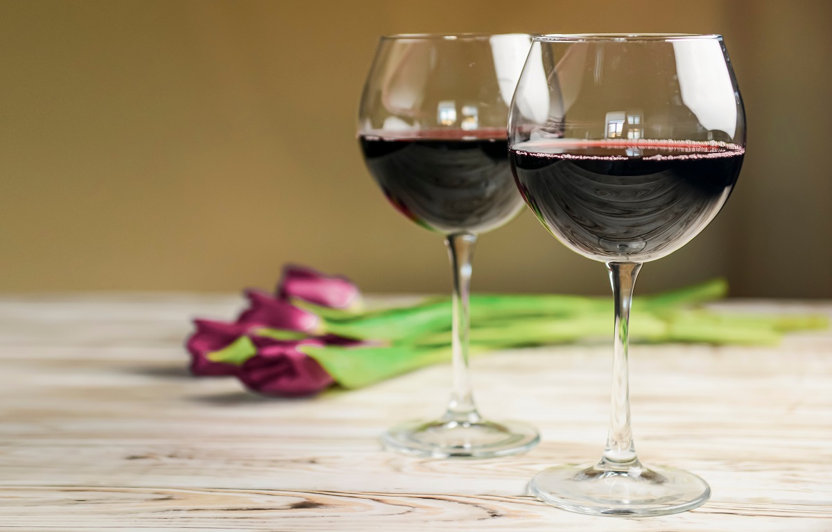 Two,Glasses,Of,Red,Wine,And,Tulips,On,A,Wooden