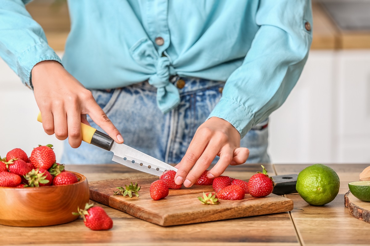 Woman,Cutting,Strawberry,For,Tasty,Lemonade,In,Kitchen,,Closeup