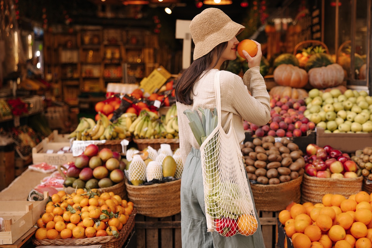 Pretty,Young,Caucasian,Woman,Checks,Orange,For,Ripeness,Standing,At