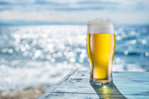 Cooled,Glass,Of,Beer,With,Condensation,Drops,On,The,Blue