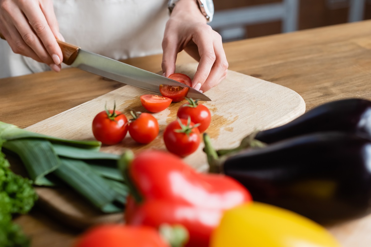 Partial,View,Of,Young,Adult,Woman,Cutting,Cherry,Tomatoes,On
