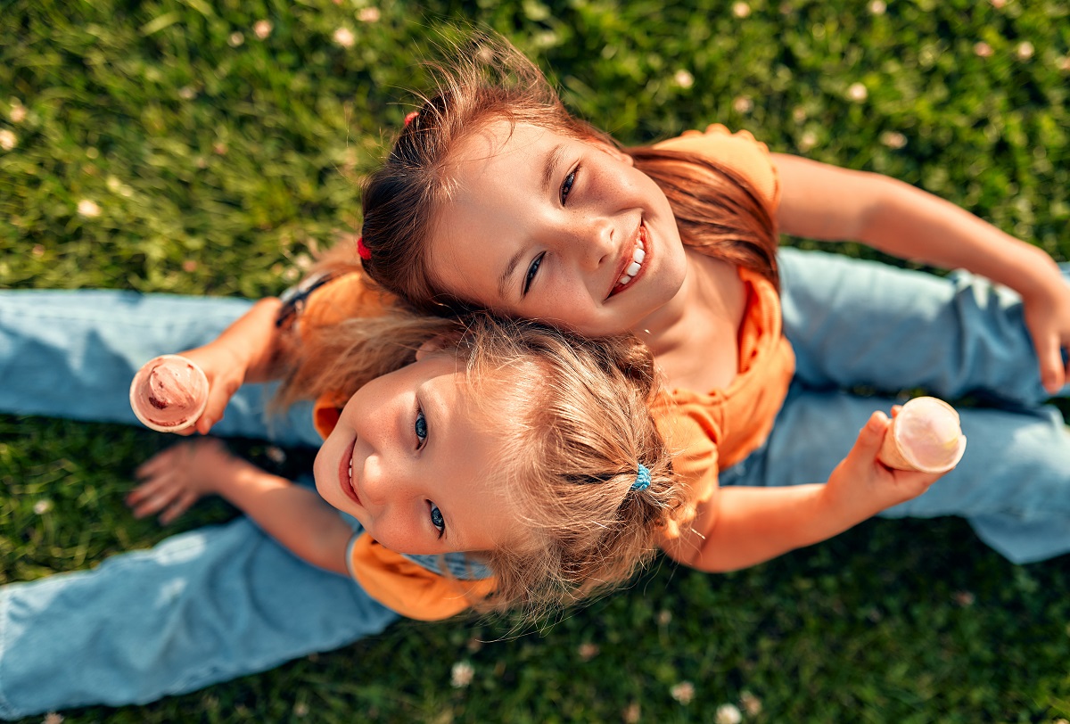 Two,Happy,Little,Sister,Girls,Sitting,In,A,Meadow,On