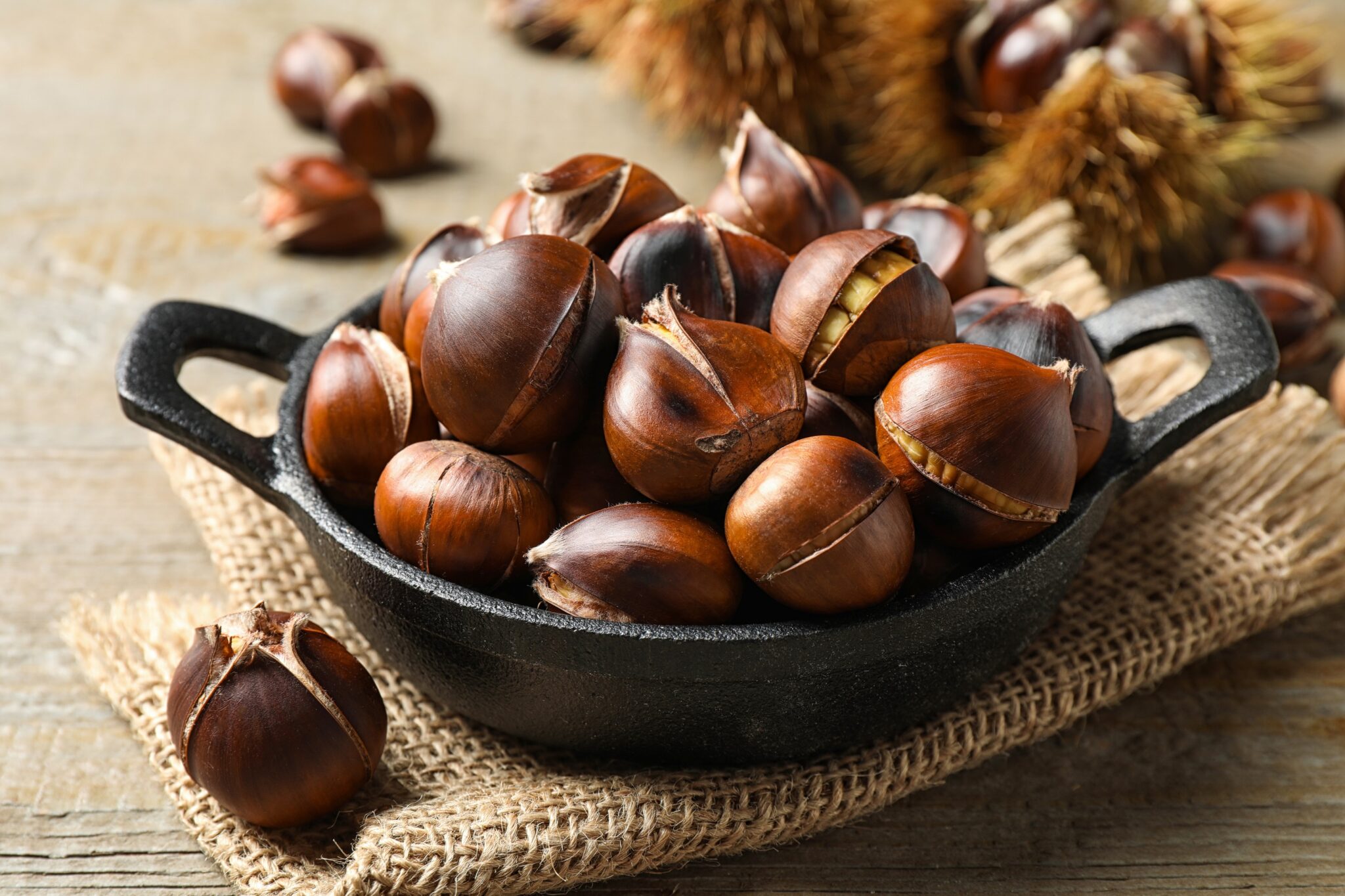 Tasty,Roasted,Edible,Chestnuts,On,Wooden,Table,,Closeup