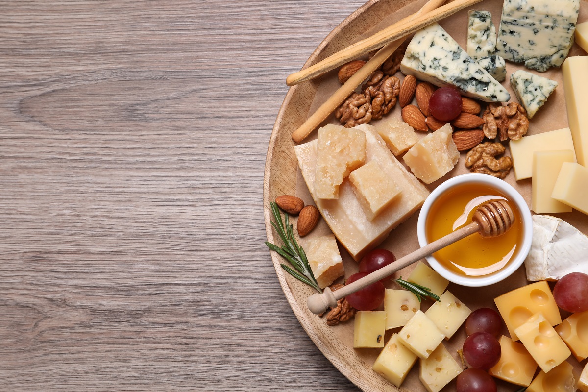 Cheese,Plate,With,Honey,,Grapes,And,Nuts,On,Wooden,Table,