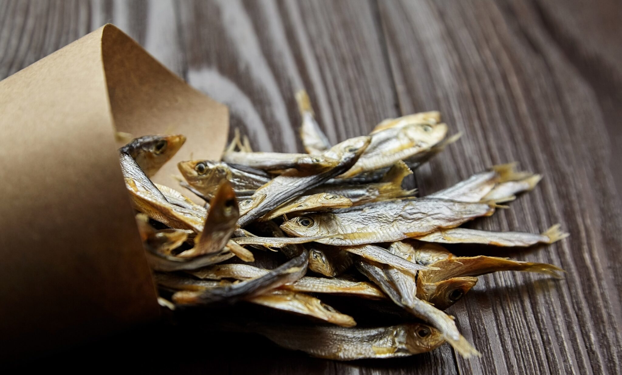 Small,Salted,Stockfish,Heap,In,Paper,Bag,On,Dark,Wooden