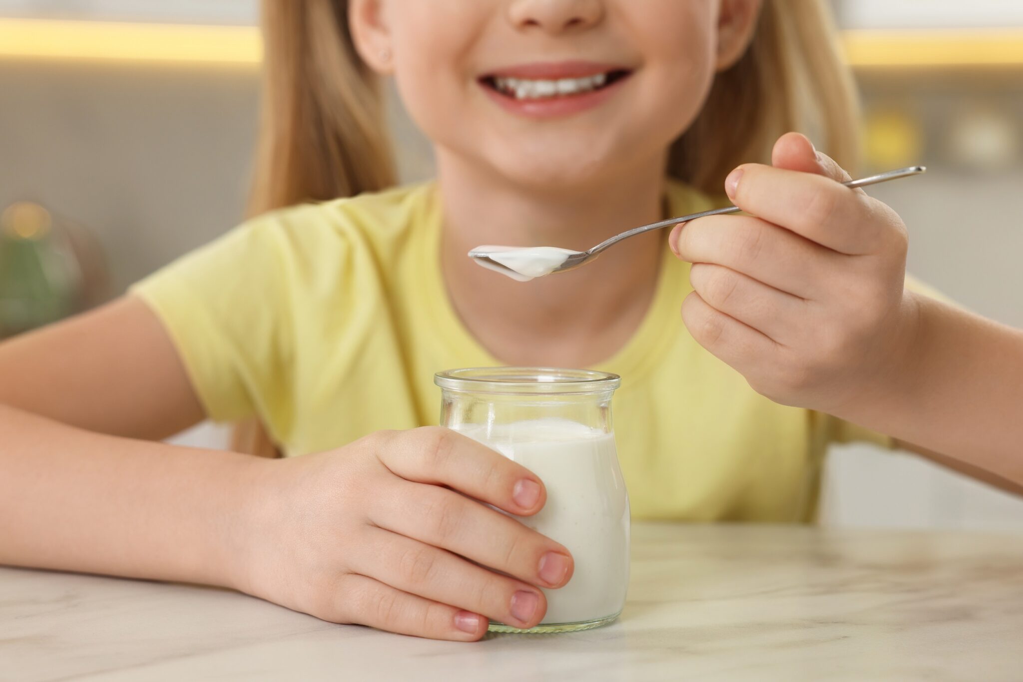 Cute,Little,Girl,With,Tasty,Yogurt,At,White,Marble,Table