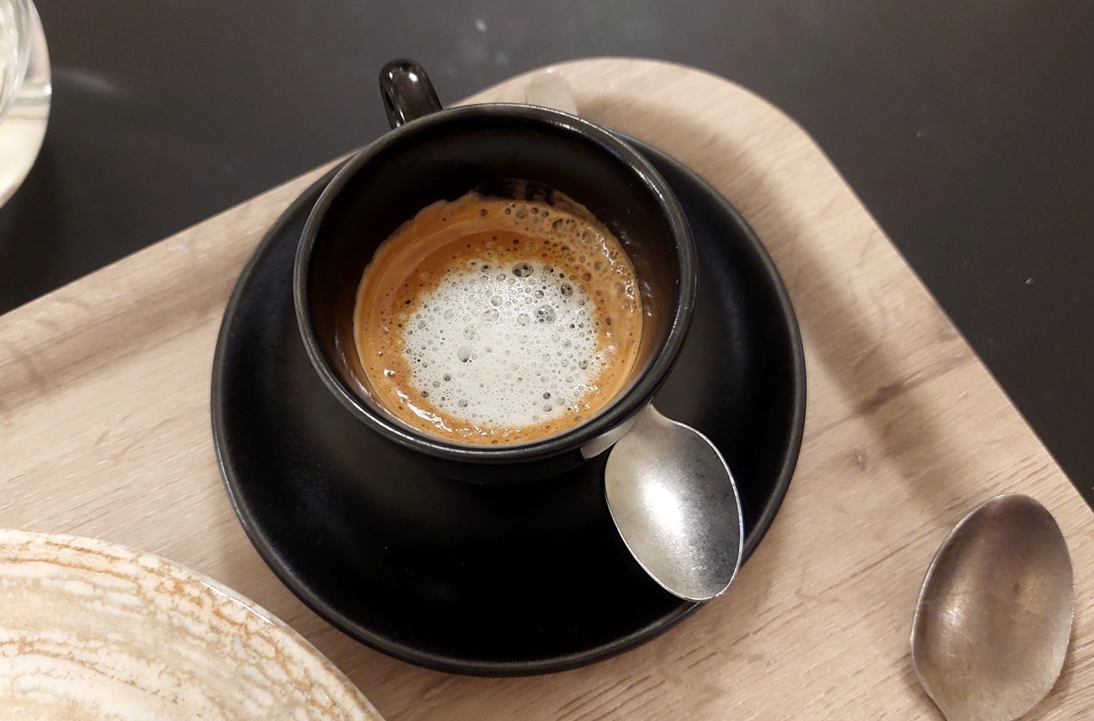 Espresso,Macchiato,In,A,Black,Coffee,Cup,With,Metal,Spoon