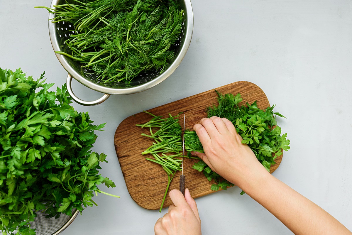 Female,Hands,Chopping,Fresh,Green,Parsley,And,Dill,(fennel),On