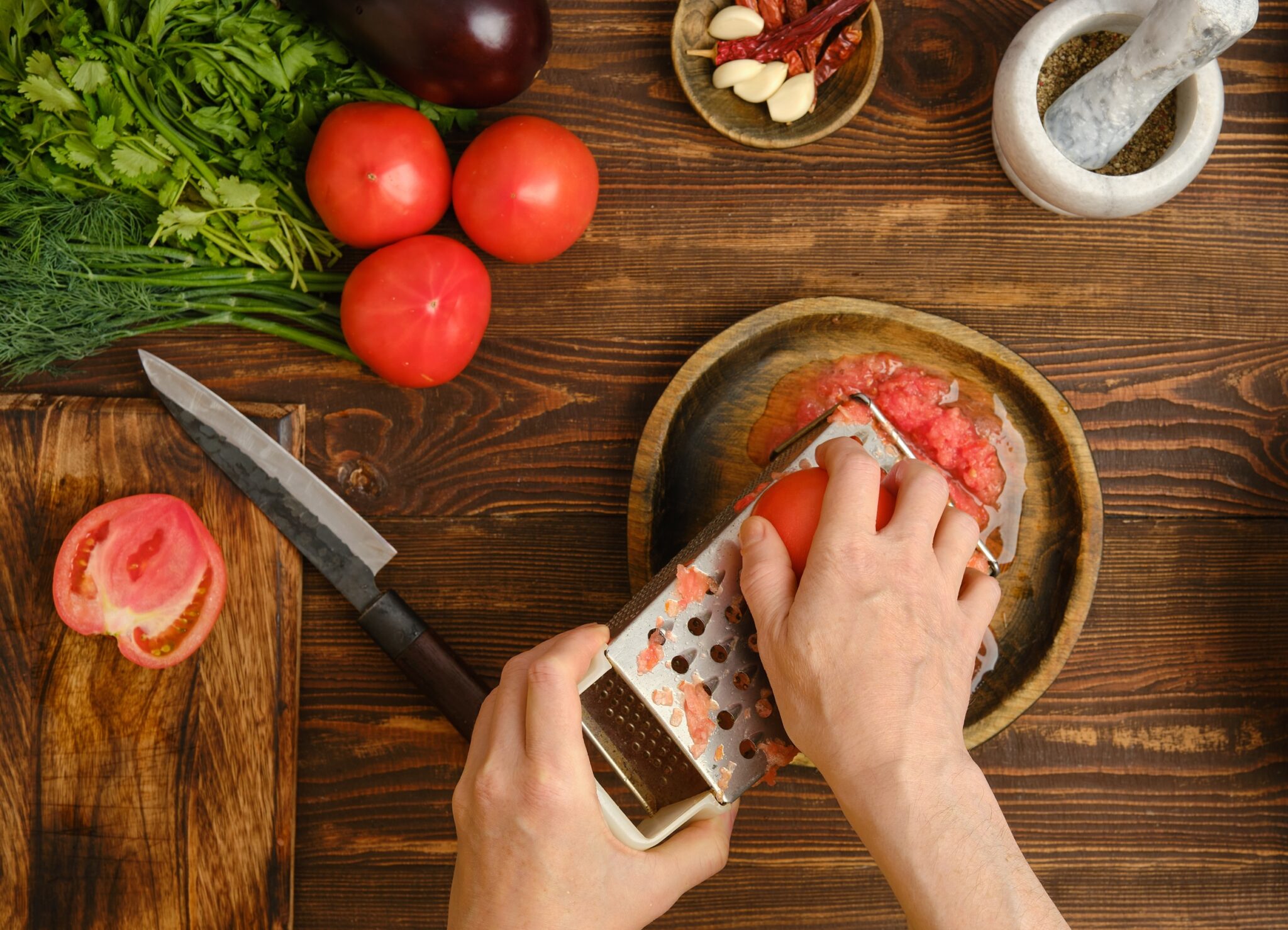 A,Person,Grates,A,Tomato,Into,A,Bowl,While,Surrounded