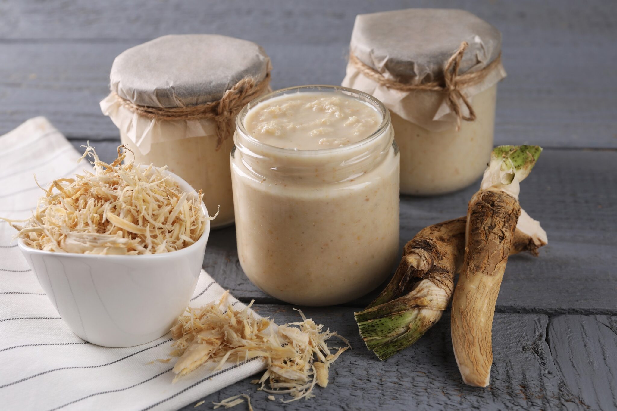 Spicy,Horseradish,Sauce,In,Jars,And,Roots,On,Grey,Wooden