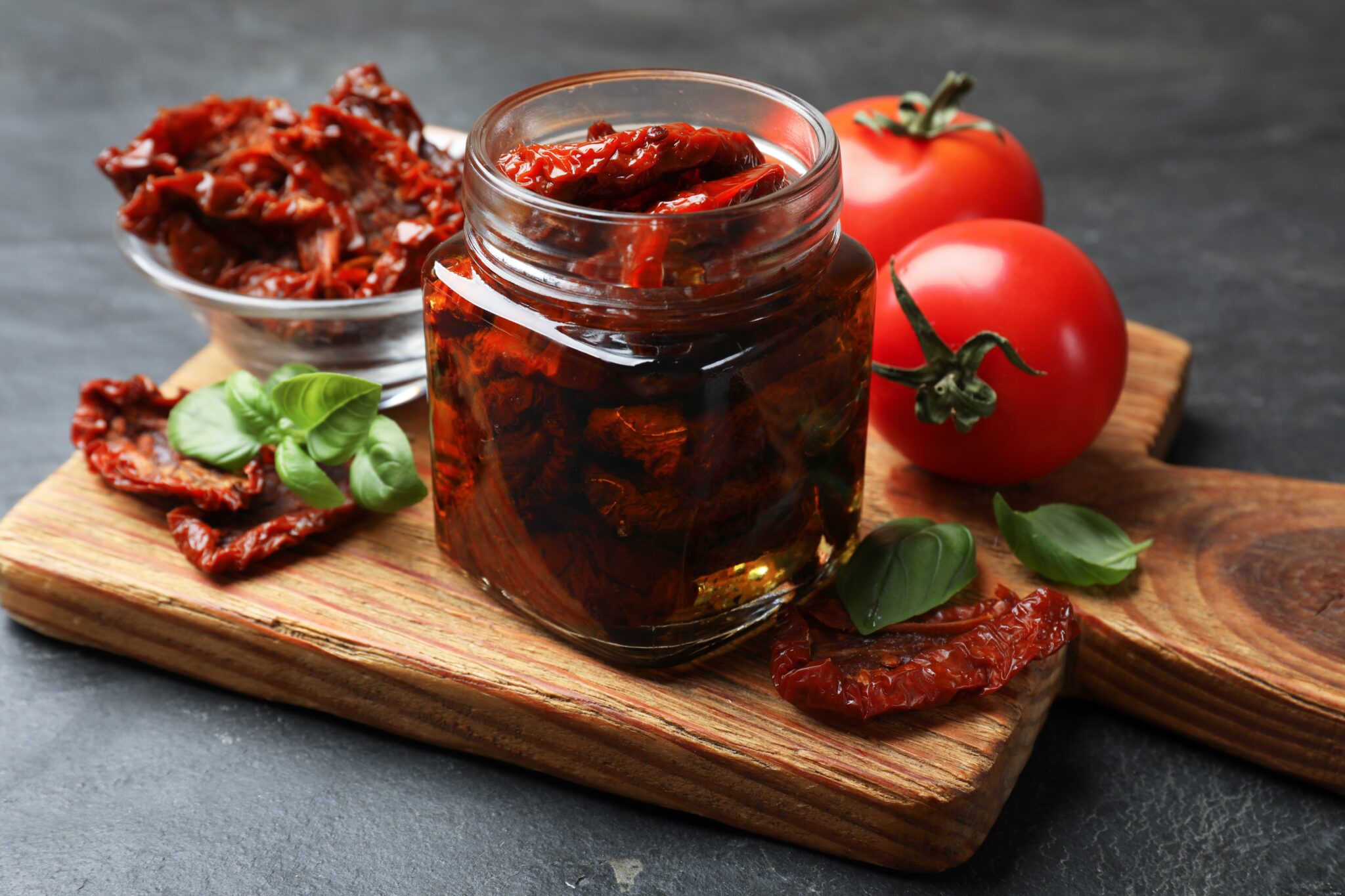 Tasty,Sun,Dried,Tomatoes,And,Fresh,Vegetables,On,Black,Table,