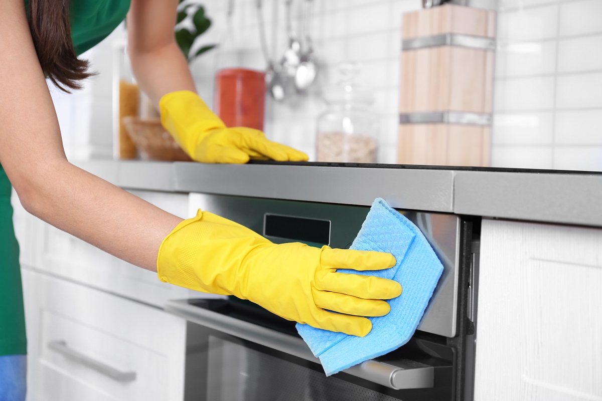 Woman,Cleaning,Oven,In,Kitchen,,Closeup