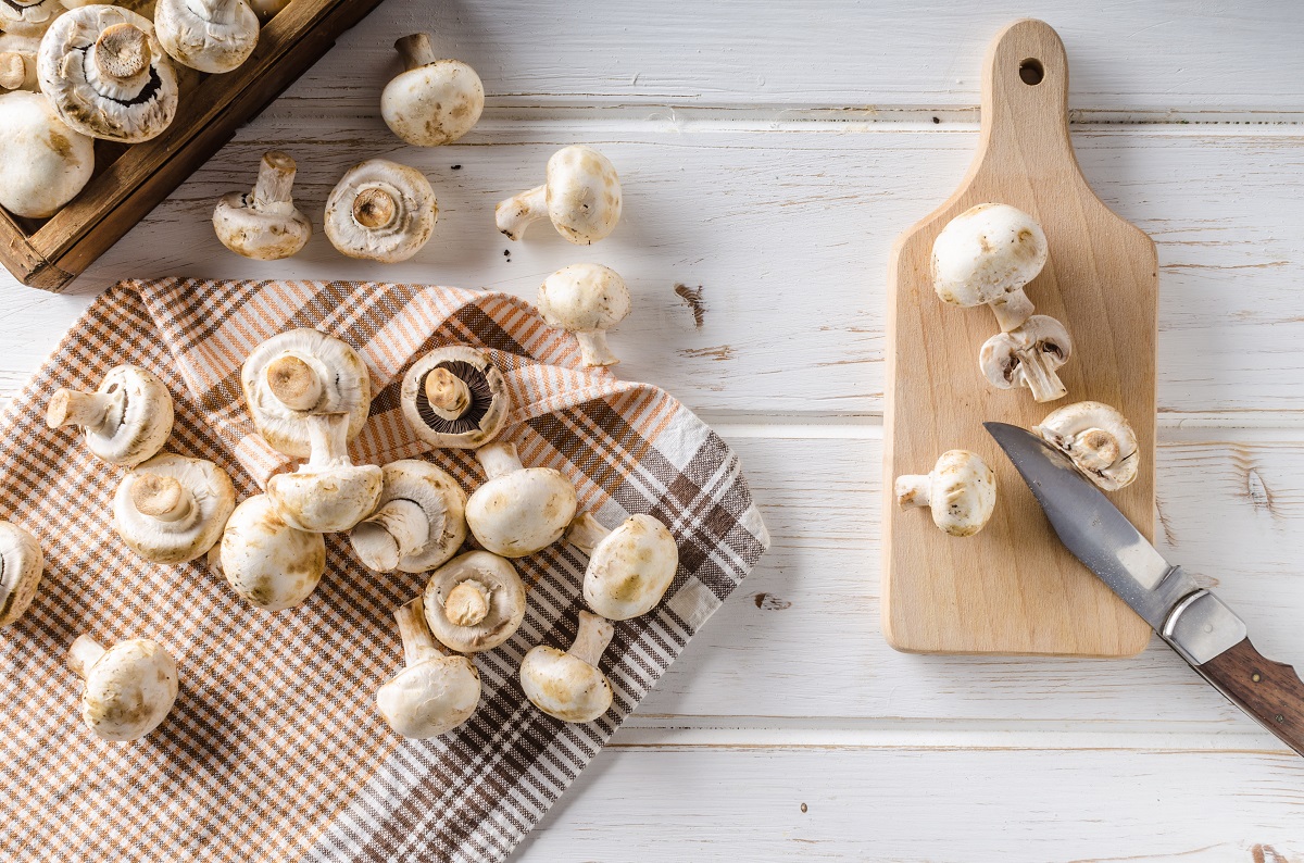 Fresh,Mushrooms,Cleaning,And,Cutting,,White,Wood,Table