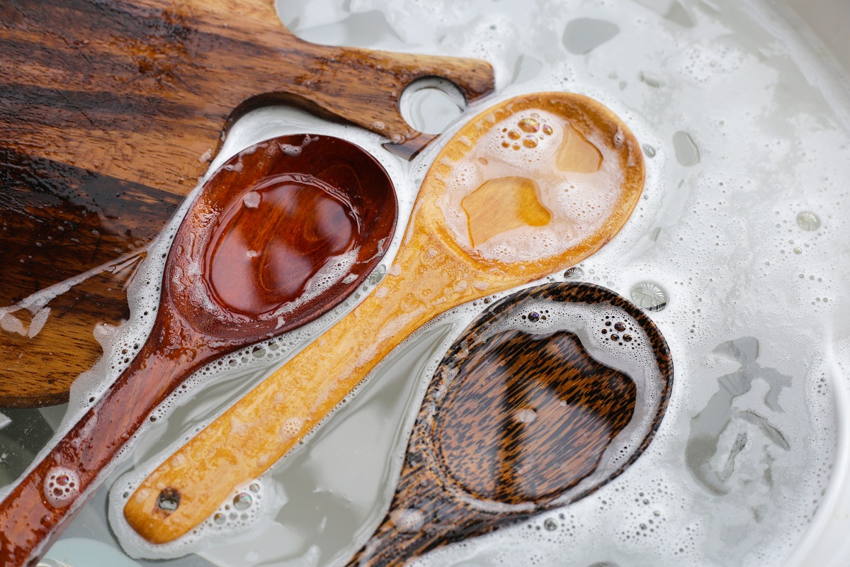 Wooden,Spoon,,Cutting,Board,And,Dishes,In,Water,And,Bubbles