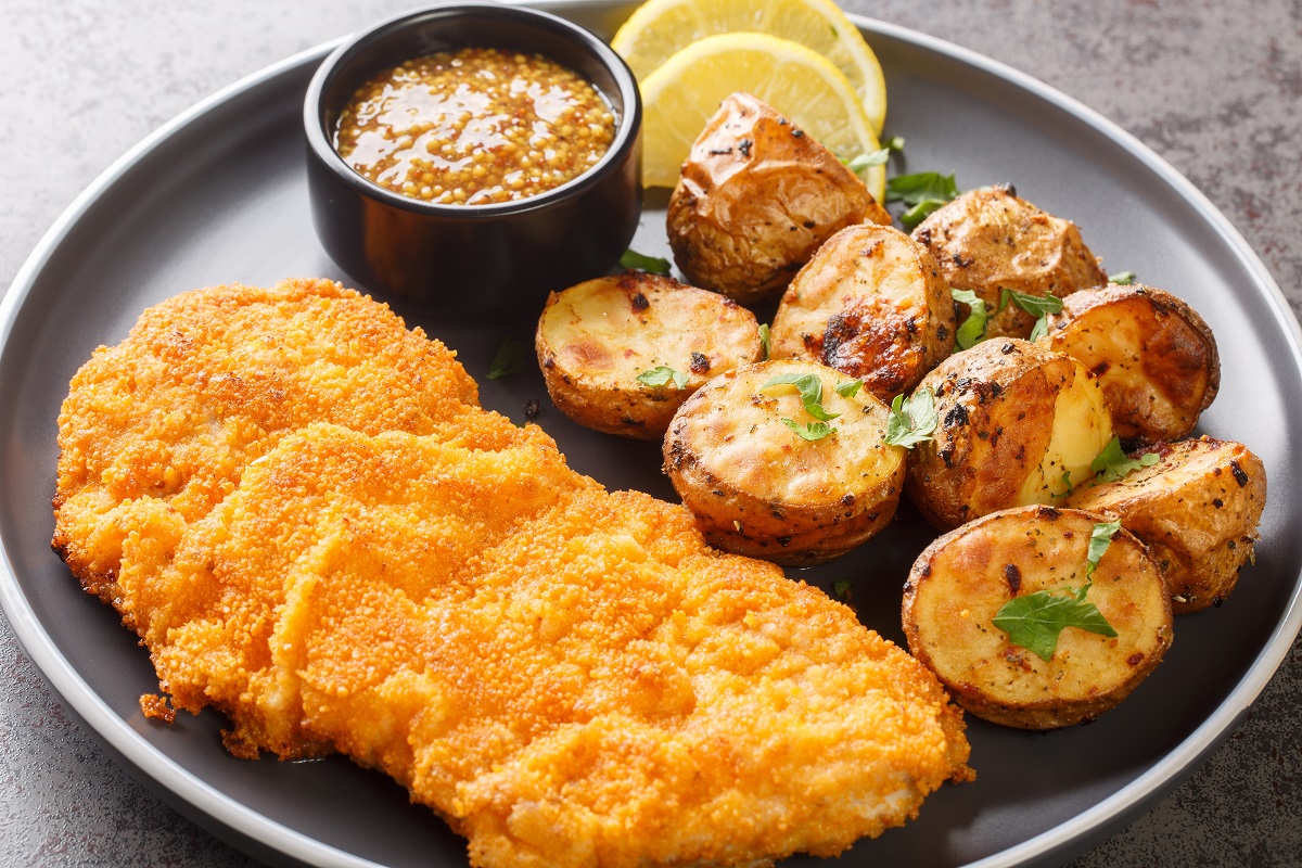 Munich,Schnitzel,Served,With,Baked,Potatoes,And,Mustard,Close-up,In