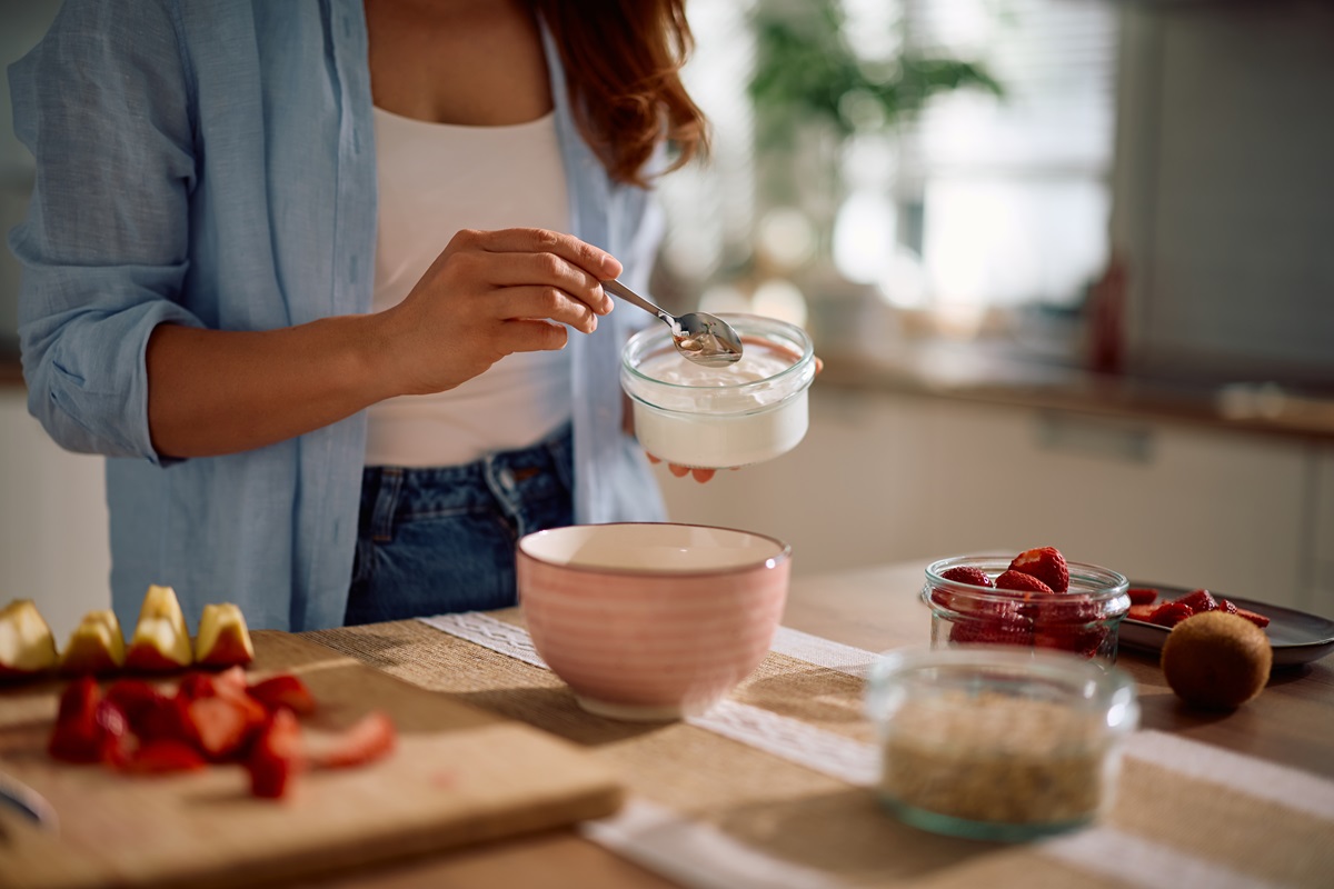 Close,Up,Of,Woman,Using,Greek,Yogurt,While,Making,Oatmeal
