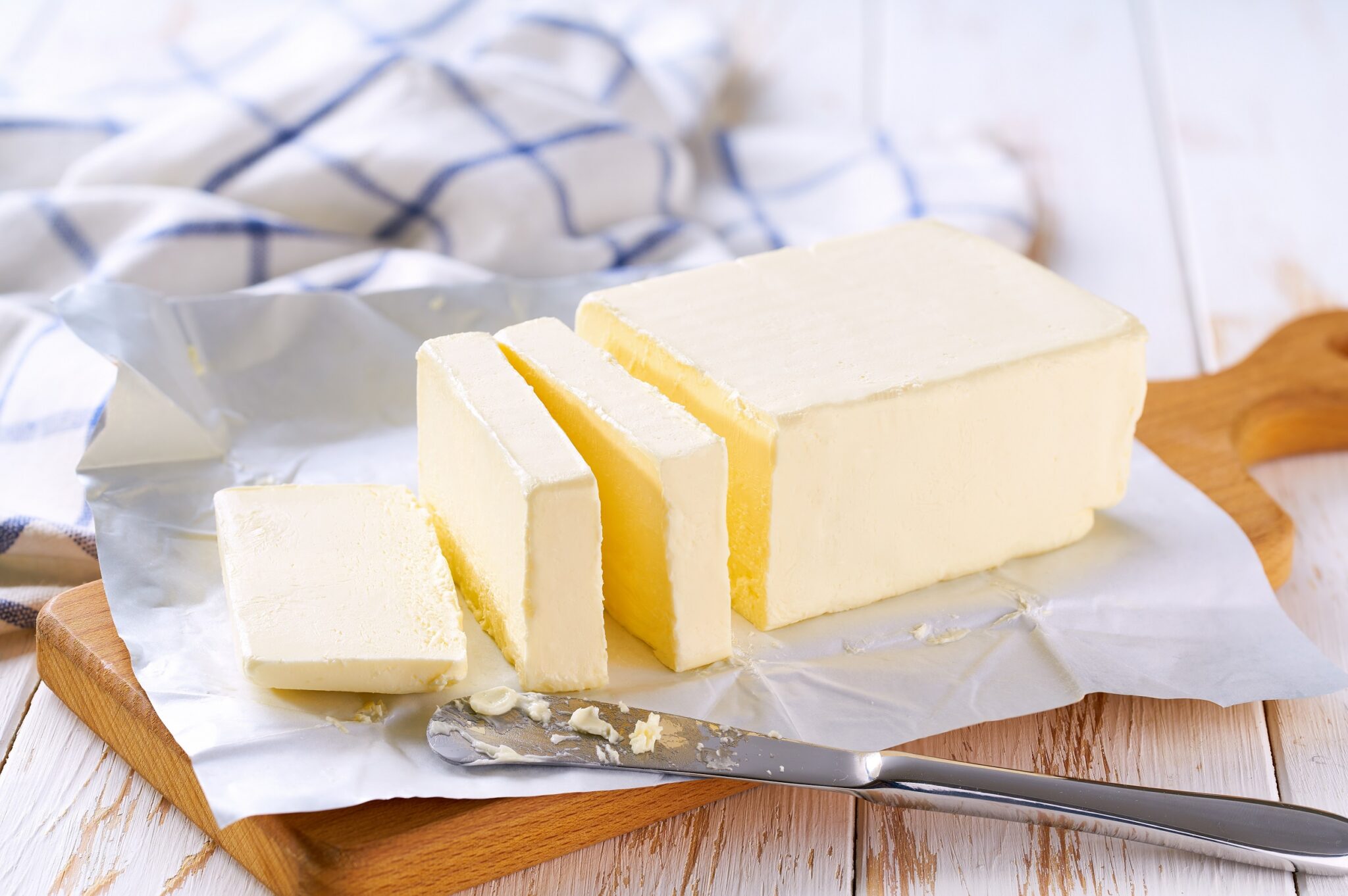 Cut,Block,Butter,On,A,Whitw,Wooden,Table,,Selective,Focus.