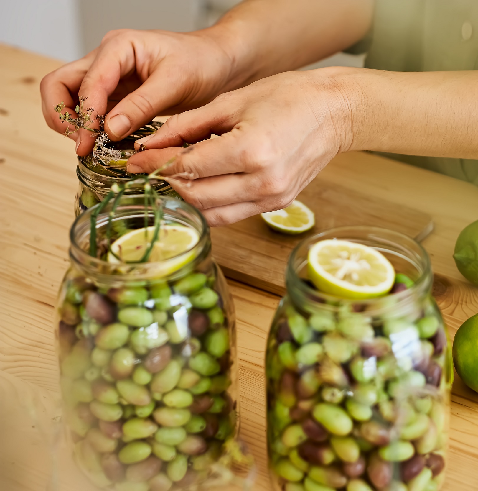 Woman,Prepares,Fermented,Olives,In,Glass,Jars,In,The,Kitchen.