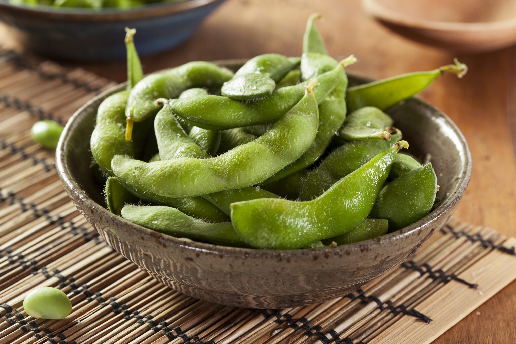 Cooked,Green,Organic,Edamame,With,Sea,Salt,Against,A,Background
