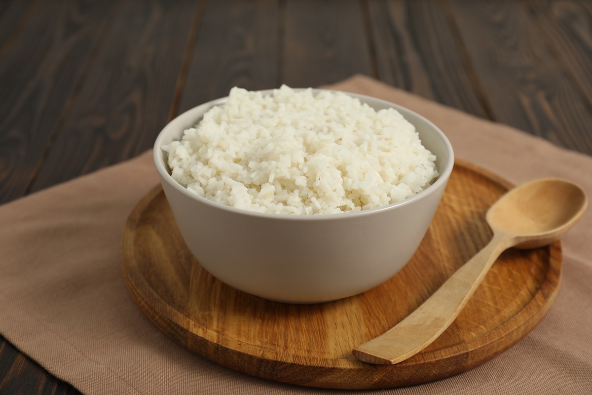 Delicious,Boiled,Rice,In,Bowl,And,Spoon,On,Wooden,Table