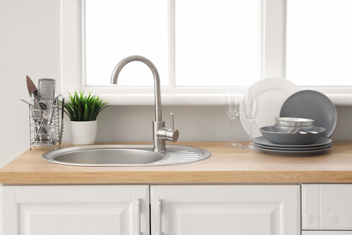 Kitchen,Counter,With,Sink,And,Clean,Dishes,Near,Window