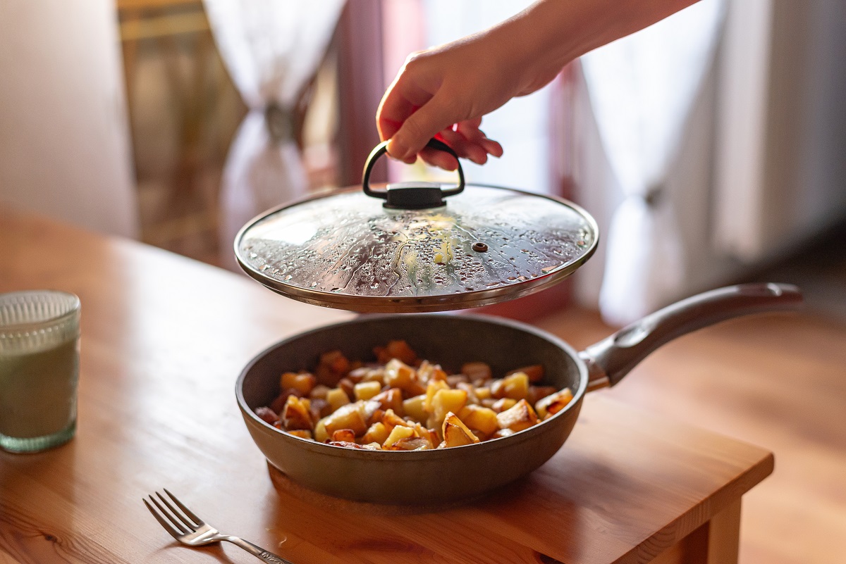 A,Cozy,Culinary,Moment:,A,Hand,Lifts,The,Lid,Off